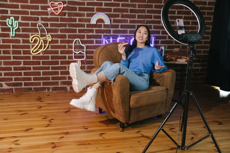 Young woman sitting on a couch shooting a video of herself